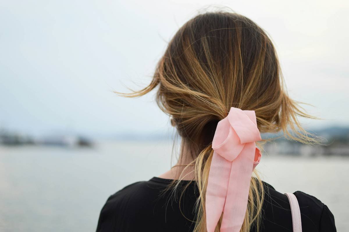 woman styling her hair with a premium everyday hair band