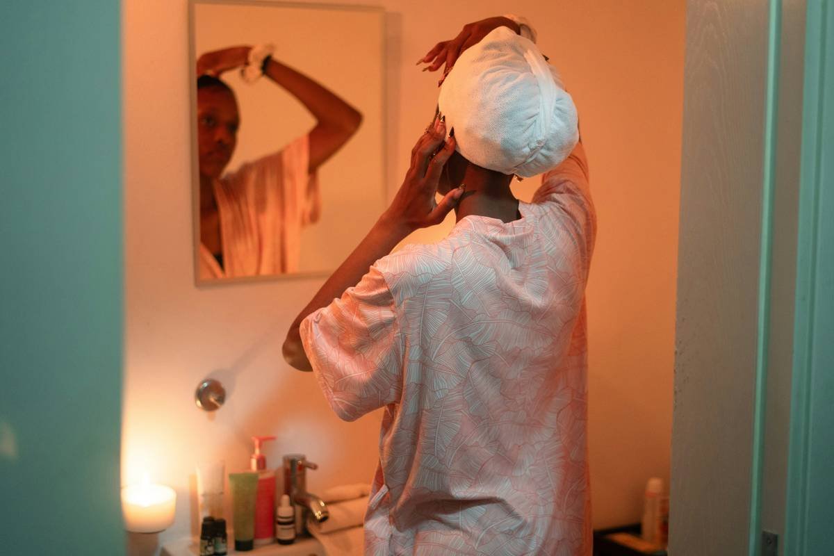 woman demonstrating relaxed hair wrap technique with satin scarf